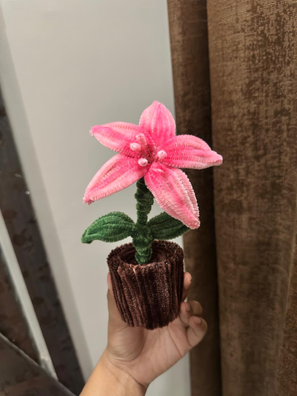 Handmade pink lily flower in a small dark pot