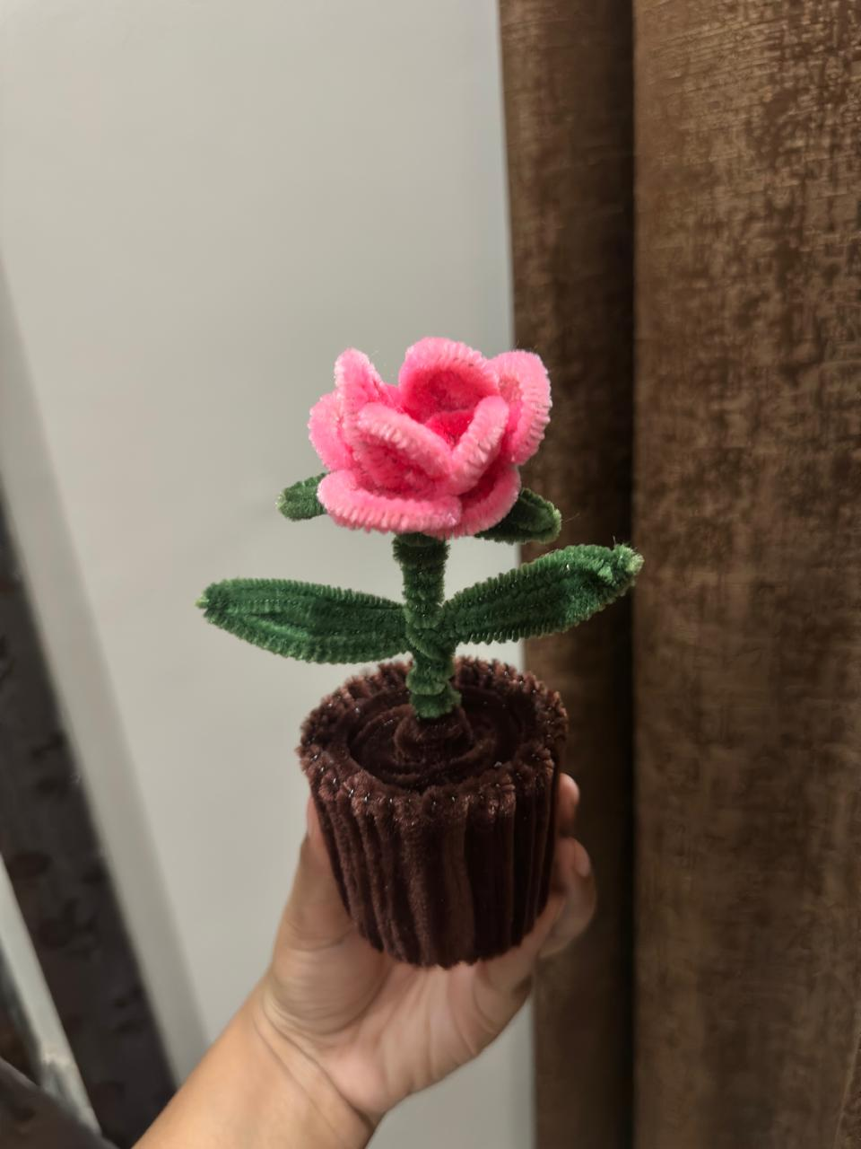 Handmade pink rose flower in a small dark pot